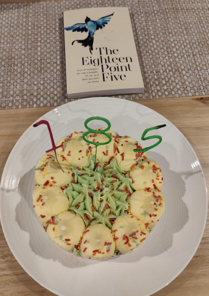 the book is at the top and sitting on a table, the white plate is holding the icecream cake and the numbers 185 are on it